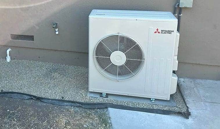 Mitsubishi Electric heat-pump condenser on a gravel pad