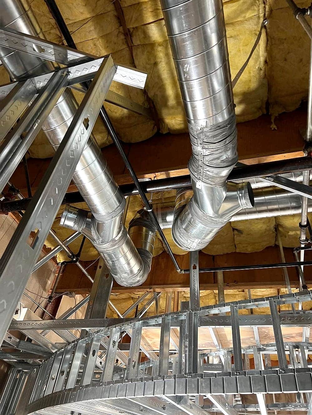 Galvanized spiral ductwork running through steel stud framing